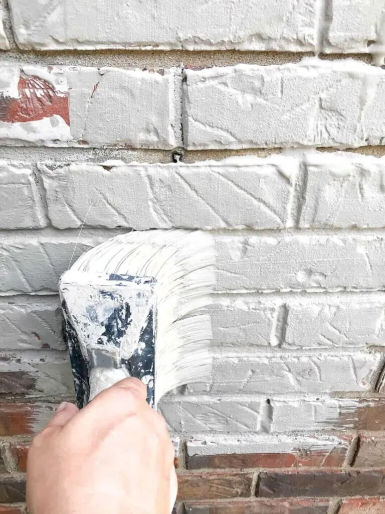 bricks with hand holding brush using for whitewash