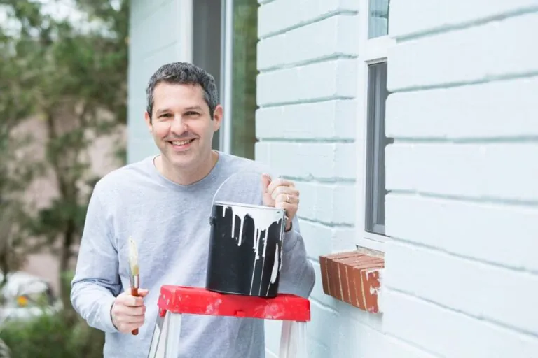 man painting house exterior