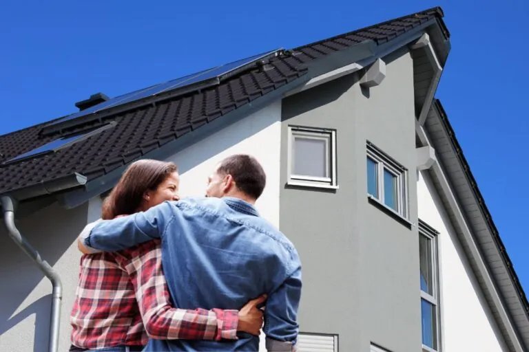 rear view of couple standing at the front of their new paint home