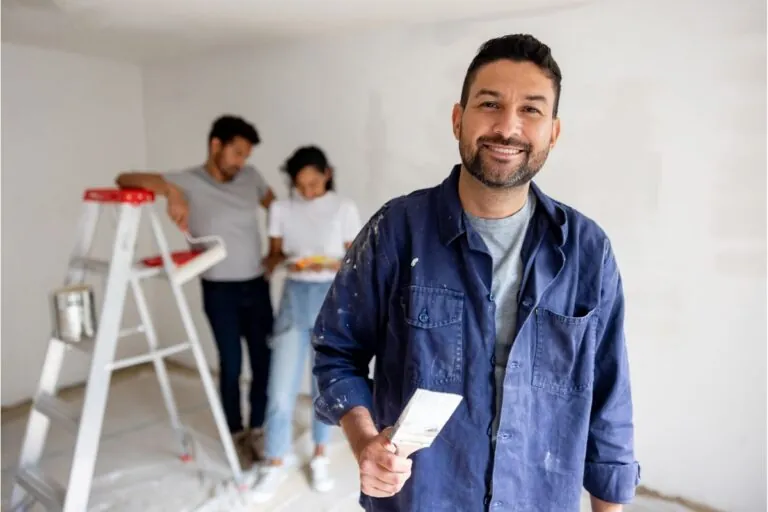 happy house painter painting a couples house