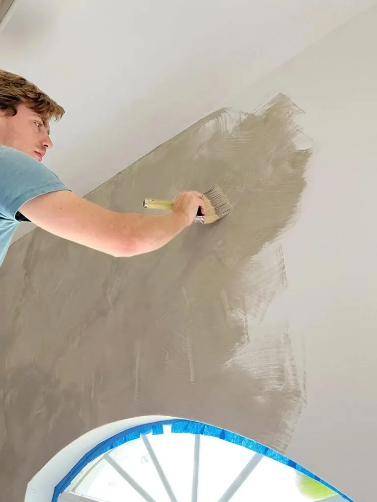 man using limewash on interior wall