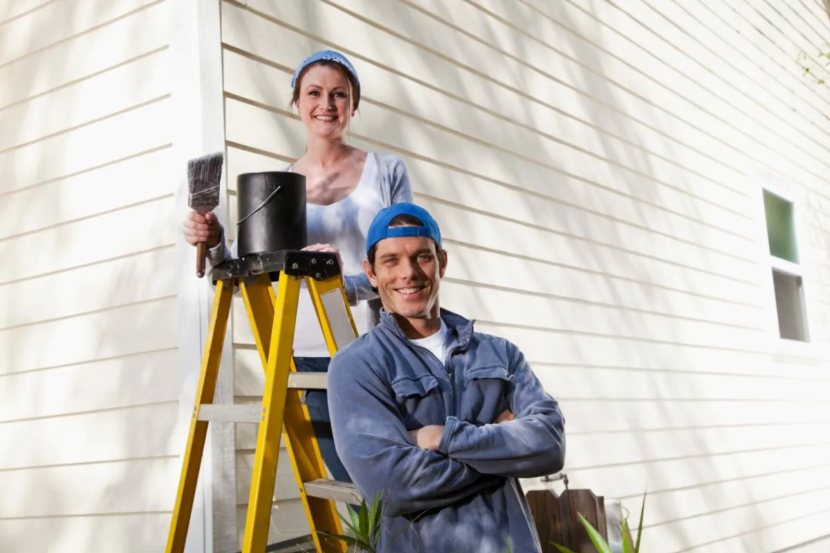 couple painting exterior house