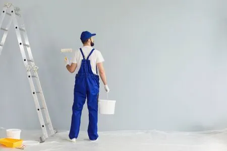 bearded painter contractor prepairing to paint wall